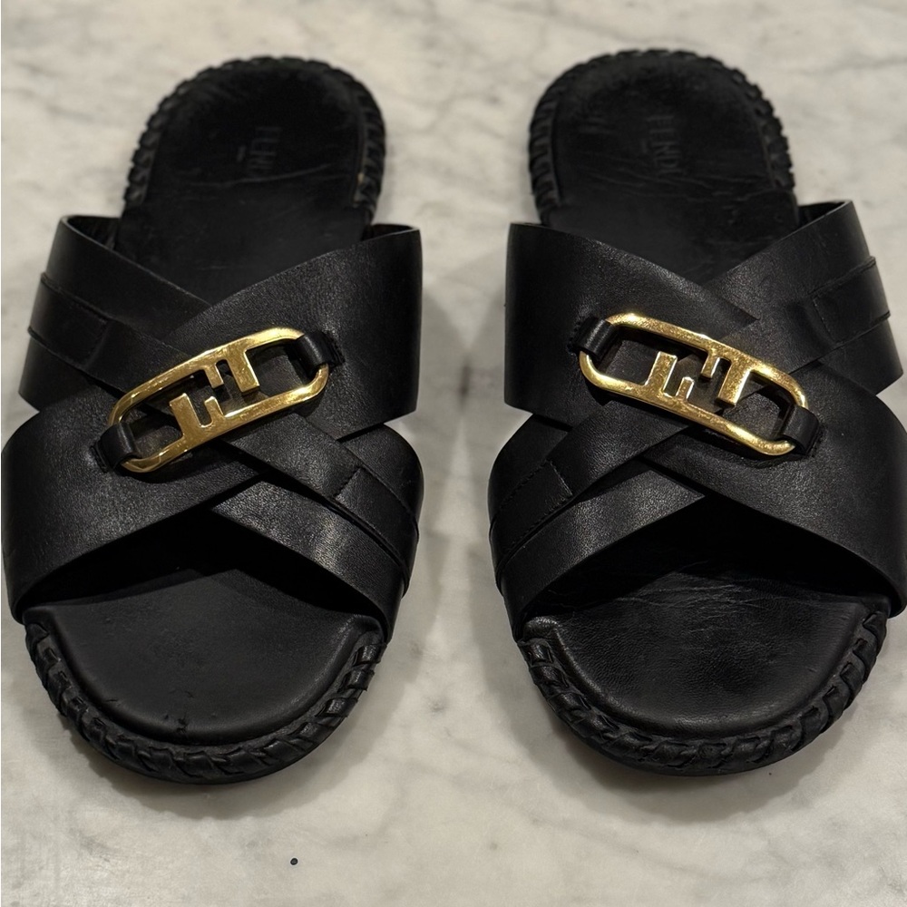 LEATHER SLIDES IN NOIR
Slides hand finished with interwoven leather strips.